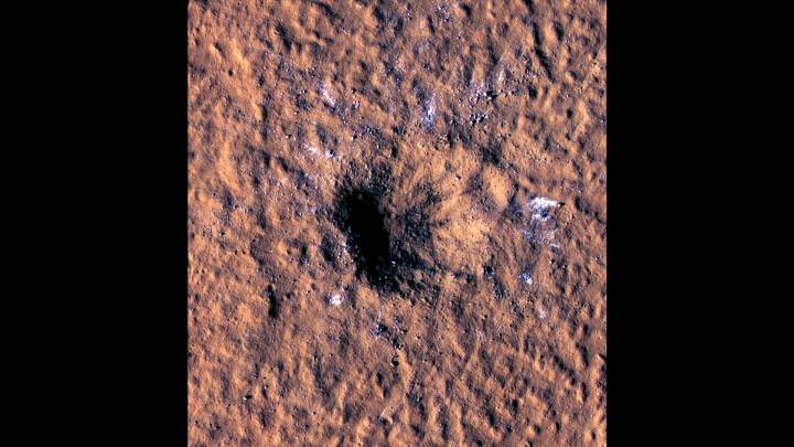 Des blocs de glace d'eau de la taille d'un rocher sont visibles sur le pourtour d'un cratère d'impact sur Mars.